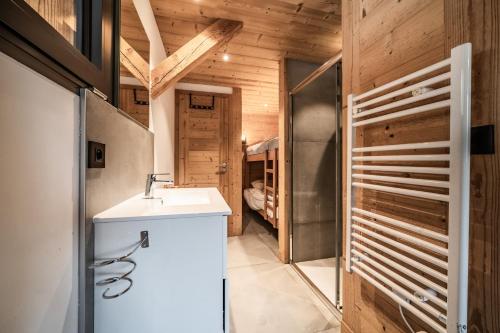 a bathroom with a sink and a shower with wooden walls at Martonne - haut Roca immobilier in Châtel