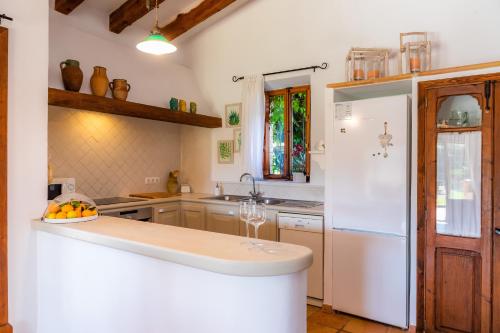 a kitchen with a white refrigerator and a sink at Finca Na Palada in Artá