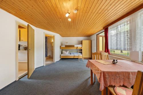 a living room with a table and a bedroom at Bungalow 4 - Kimbucht in Reichendorf