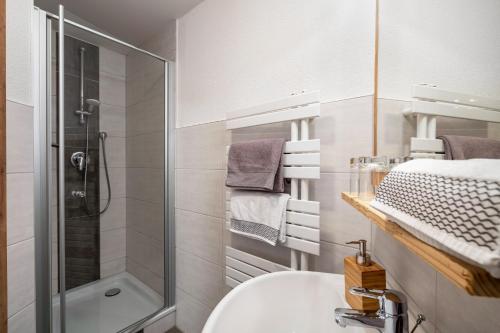 a white bathroom with a shower and a sink at Schätzlehof in Oberwinden