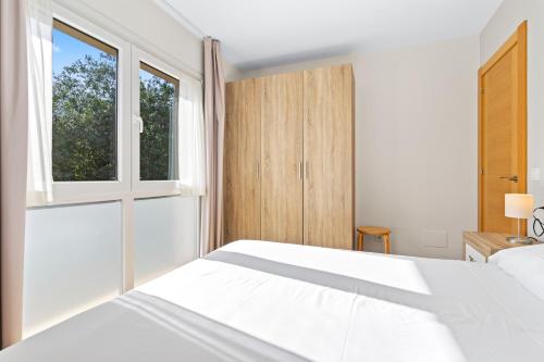 a bedroom with a white bed and a window at 4 Terraza - Antilles sin jardin in Llanes