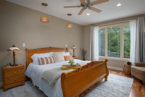 ein Schlafzimmer mit einem großen Bett und einem Deckenventilator in der Unterkunft Brevard Basecamp · Brevard Basecamp fireplace in Primary BR in Brevard