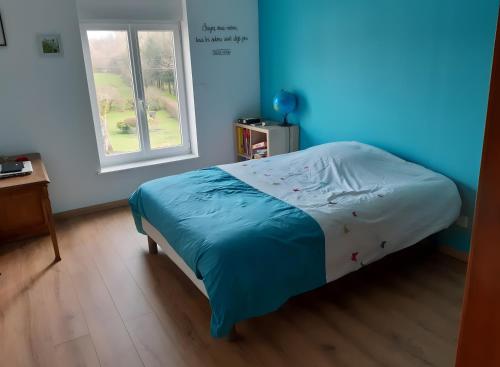 a bed in a room with a window at La Grange Aux Oiseaux in Beaulieu