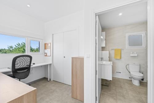 a bathroom with a toilet and a desk with a chair at Macisvenda relax in Macisbenda