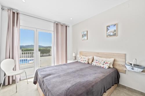 a white bedroom with a bed and a balcony at Macisvenda relax in Macisbenda