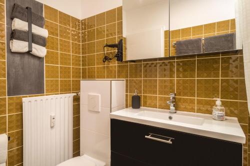 a bathroom with a sink and a refrigerator at Heimelig im Hirschen App 240 in Schönwald