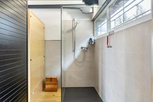 a shower with a glass door in a bathroom at Das Schwarzwälder Speckhuisli in Grafenhausen