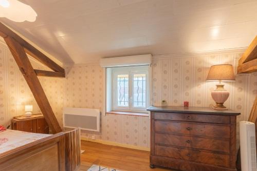a bedroom with a bed and a dresser and a window at O’bord Du Gave in Saucède