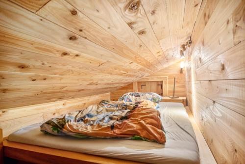 a bed in a room with a wooden wall at Eifelyeti Ferienwohnung mit Sauna in Ellscheid