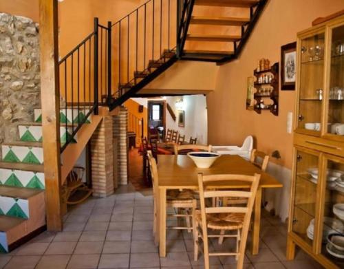 a dining room with a wooden table and a staircase at Casa Jara in Azuara