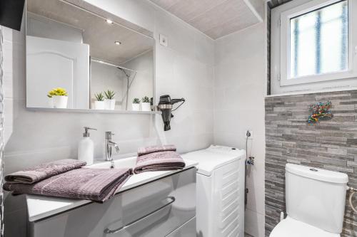 a white bathroom with a sink and a toilet at Villa Nui in Cuers