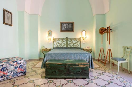 a bedroom with a bed and a chair at Donna Cesarina - Maison de Charme in Maruggio