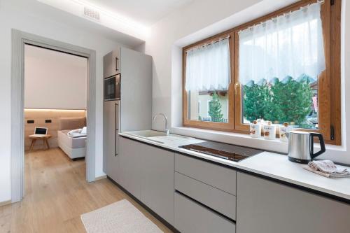 a white kitchen with a sink and a window at Chalet Ale Livigno in Livigno