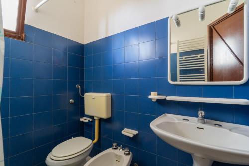 a blue tiled bathroom with a toilet and a sink at La Castellana in Gallipoli