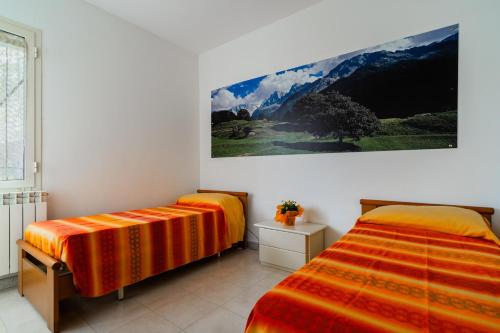 a bedroom with two beds and a painting on the wall at La Castellana in Gallipoli