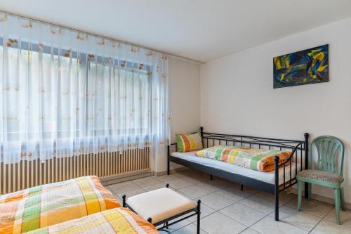 a bedroom with two beds and a chair and a window at Ferienwohnung Frechehof 74qm in Bad Peterstal