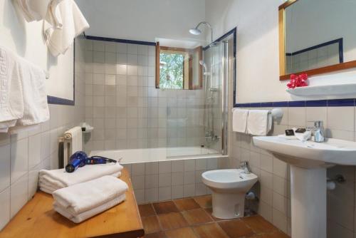 a bathroom with a sink and a tub and a toilet at Llangana in Pollença