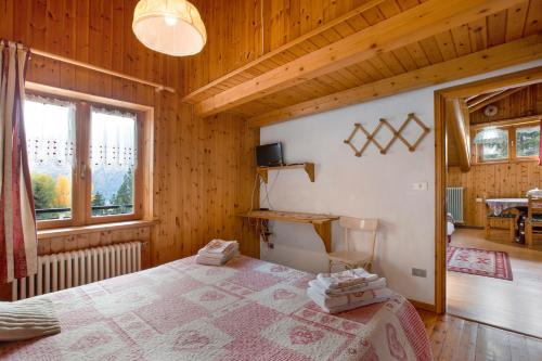 a bedroom with a bed in a wooden house at Piccolo Paradiso in Cogne