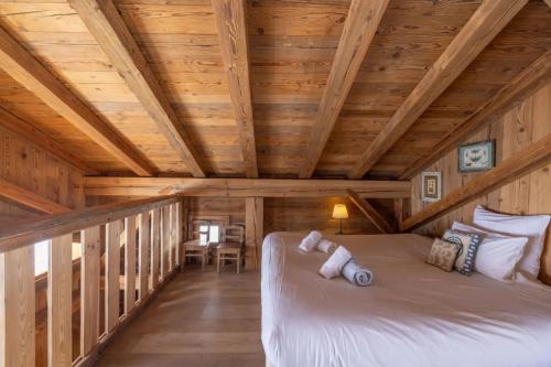 a bed in a log cabin with wooden ceilings at Mazot de Warens in Combloux