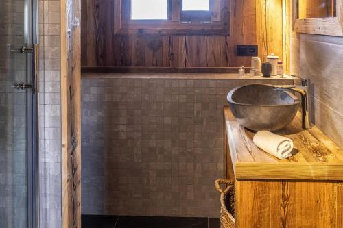 a bathroom with a sink on a wooden counter at Mazot de Warens in Combloux