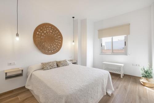 a white bedroom with a bed and a window at Salitre in Las Eras