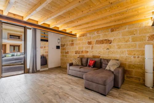 a living room with two couches and a brick wall at Casa Incanto in Presicce