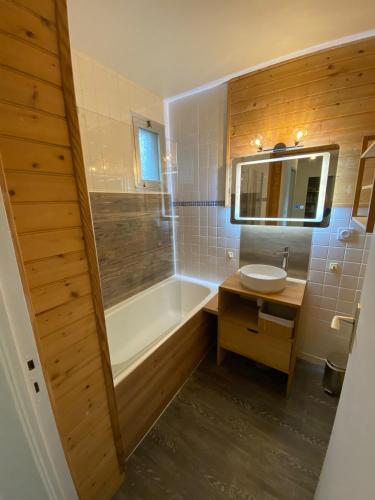 a bathroom with a tub and a sink at Le Lodge d Angèle in Honfleur