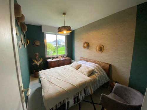 a bedroom with a bed and a window and a chair at Le Lodge d Angèle in Honfleur
