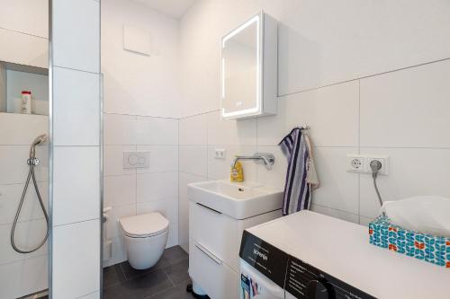 a small white bathroom with a sink and a toilet at Studio im Grünen und Bodenseenähe in Rielasingen-Worblingen