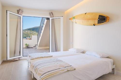 a bedroom with a bed with a surfboard on the wall at Mojo Surf Yoga House in La Orotava