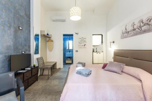 a bedroom with a large bed and a television at Casa Luna in Pozzallo