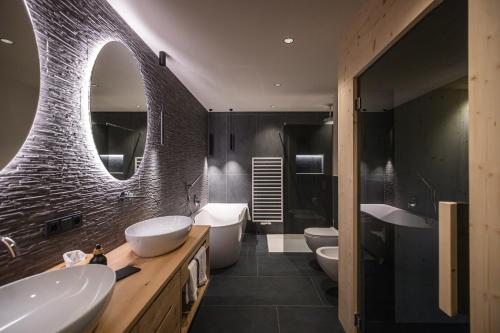 a bathroom with two sinks and two toilets at Rueper Hof Chalet Dolomit in Valdaora