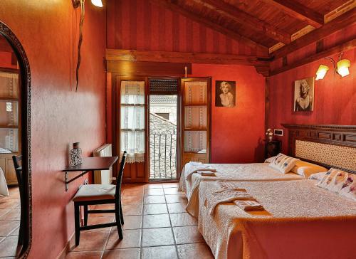 a bedroom with two beds and a desk and a window at El Lagar in Canalejas de Peñafiel