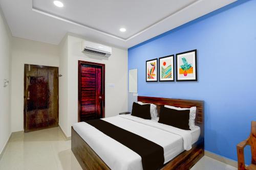 a bedroom with a large bed with a blue wall at Super HOTEL O GOLDEN CITY INN in Maula Ali