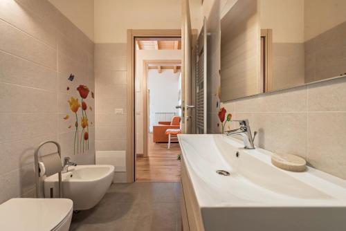 a bathroom with a white sink and a toilet at Nonno Bigi Tulipano in Tremosine Sul Garda