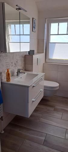 a bathroom with a sink and a toilet and a mirror at Fewo Sandbank in Pellworm