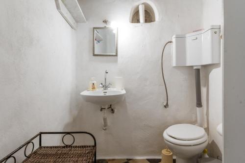 a white bathroom with a toilet and a sink at Haus Nikos - Tinos - Arnados in Arnados