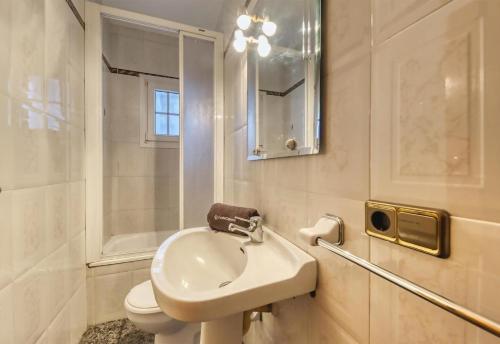 a bathroom with a sink and a toilet and a mirror at Costacabana - Villa Rosa in Lloret de Mar