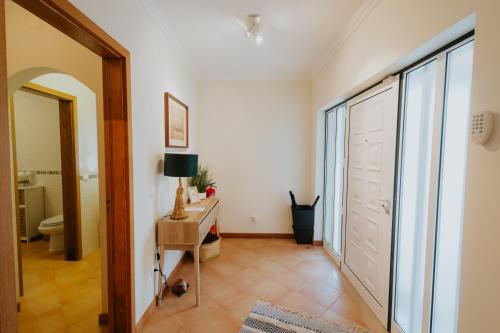 a hallway with a bathroom with a toilet and a door at Casa das Camarinhas in Murtinheira