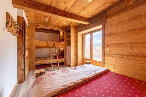 a bedroom with a bed in a wooden room at Gite Les Clapières in La Giettaz
