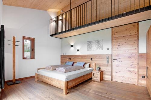 a bedroom with a bed and a wooden wall at Ansitz Röfen in Burgusio