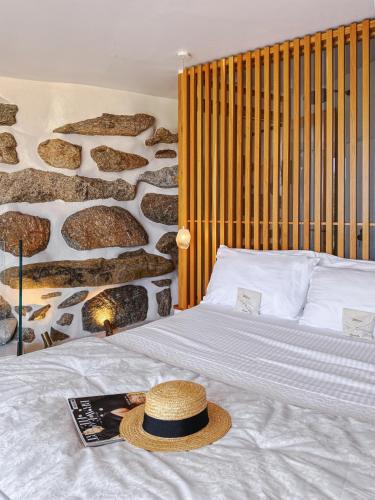 a bed with a straw hat on top of it at Alegria Mykonos 7 Suites in Kalafatis