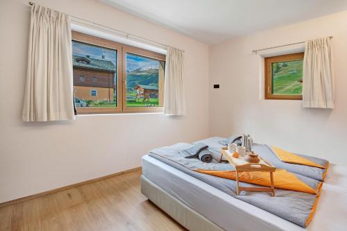 a bedroom with a bed and two windows at Chalet Ale Livigno in Livigno