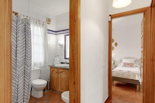 a bathroom with a toilet and a sink and a mirror at La Casa Amarilla in El Paso
