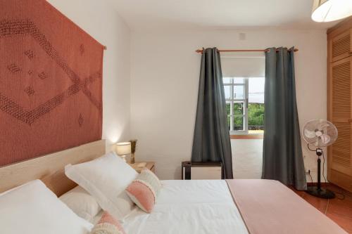 a bedroom with a white bed and a window at La Casa Amarilla in El Paso