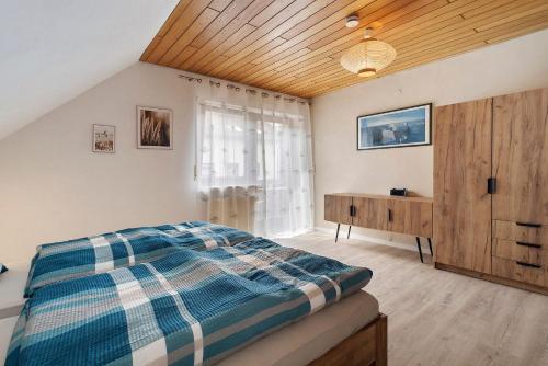 a bedroom with a bed and a wooden ceiling at Gerda Ferienwohnung in Weigendorf