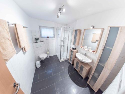 a bathroom with a sink and a shower and a toilet at Ferienwohnung Mai, 63qm in Plettenberg