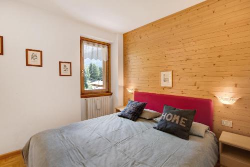 a bedroom with a bed with a wooden wall at Chalet Holly in Bormio