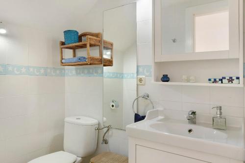 a white bathroom with a toilet and a sink at Free Airport Shuttle and Parking in San Bartolomé