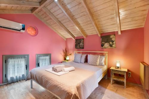 a bedroom with a large bed with pink walls at Villa Fotini Lefkada in Lefkada